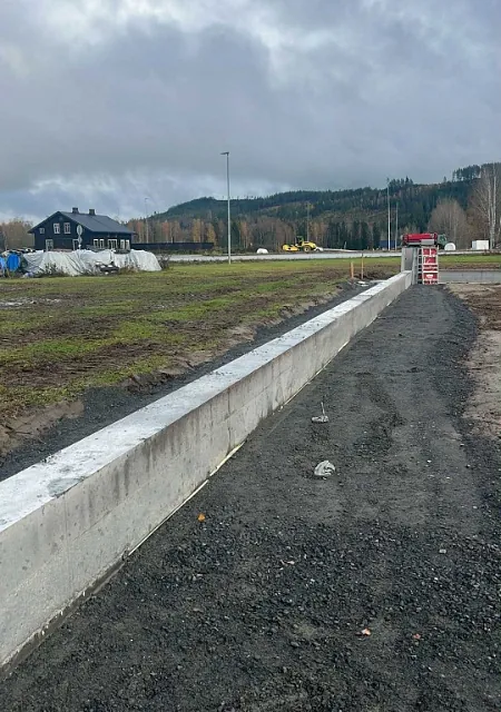 Nystøpt betongmur langs tomt i landlig område
