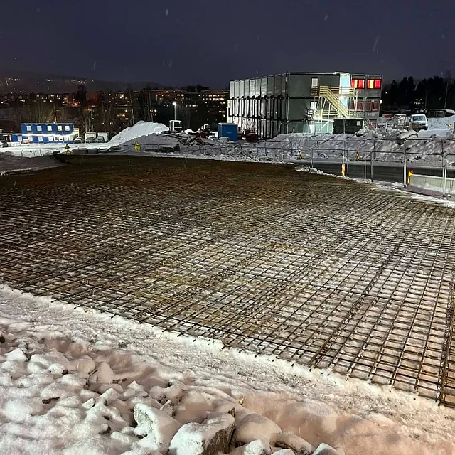 Armeringsjern for betongplate på byggeplass om kvelden