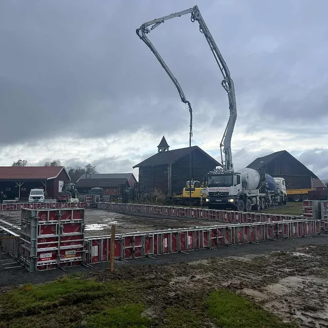 Betongpumpe støper fundament med forskaling på byggeplass