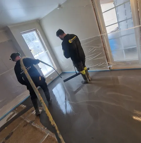 Arbeidere legger gulv med slitesterk base