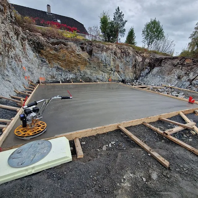 Nystøpt betongplate i fjellskjæring med avrettingsmaskin